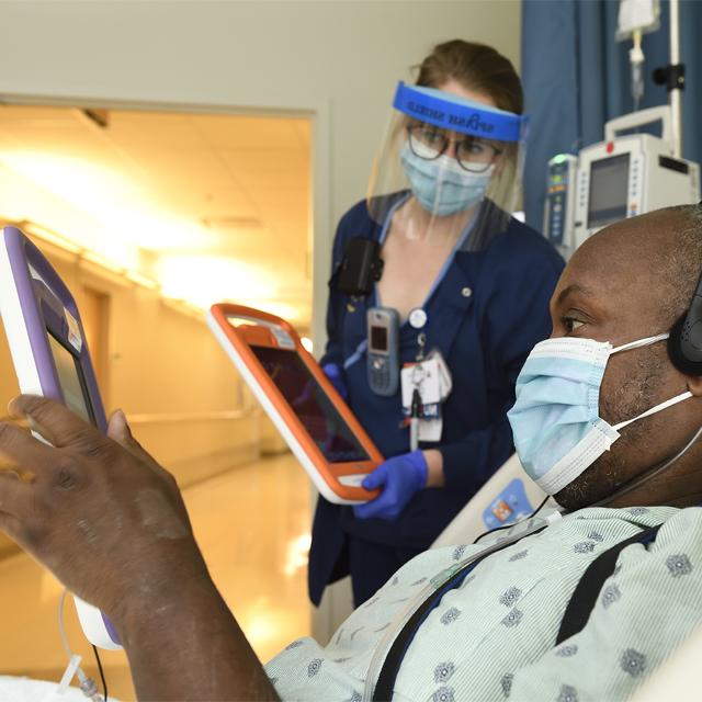 A photo shows a patient in the hospital using a tablet. 
