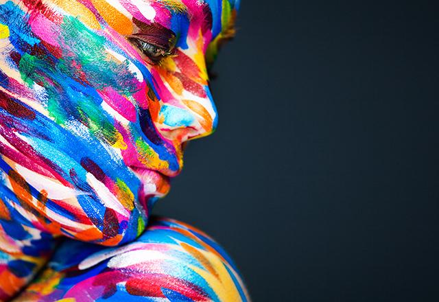 Person with multiple colors of paint on their face.