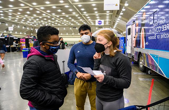 Members of the mobile vaccine team give information to a CIAA Fan Fest attendee.